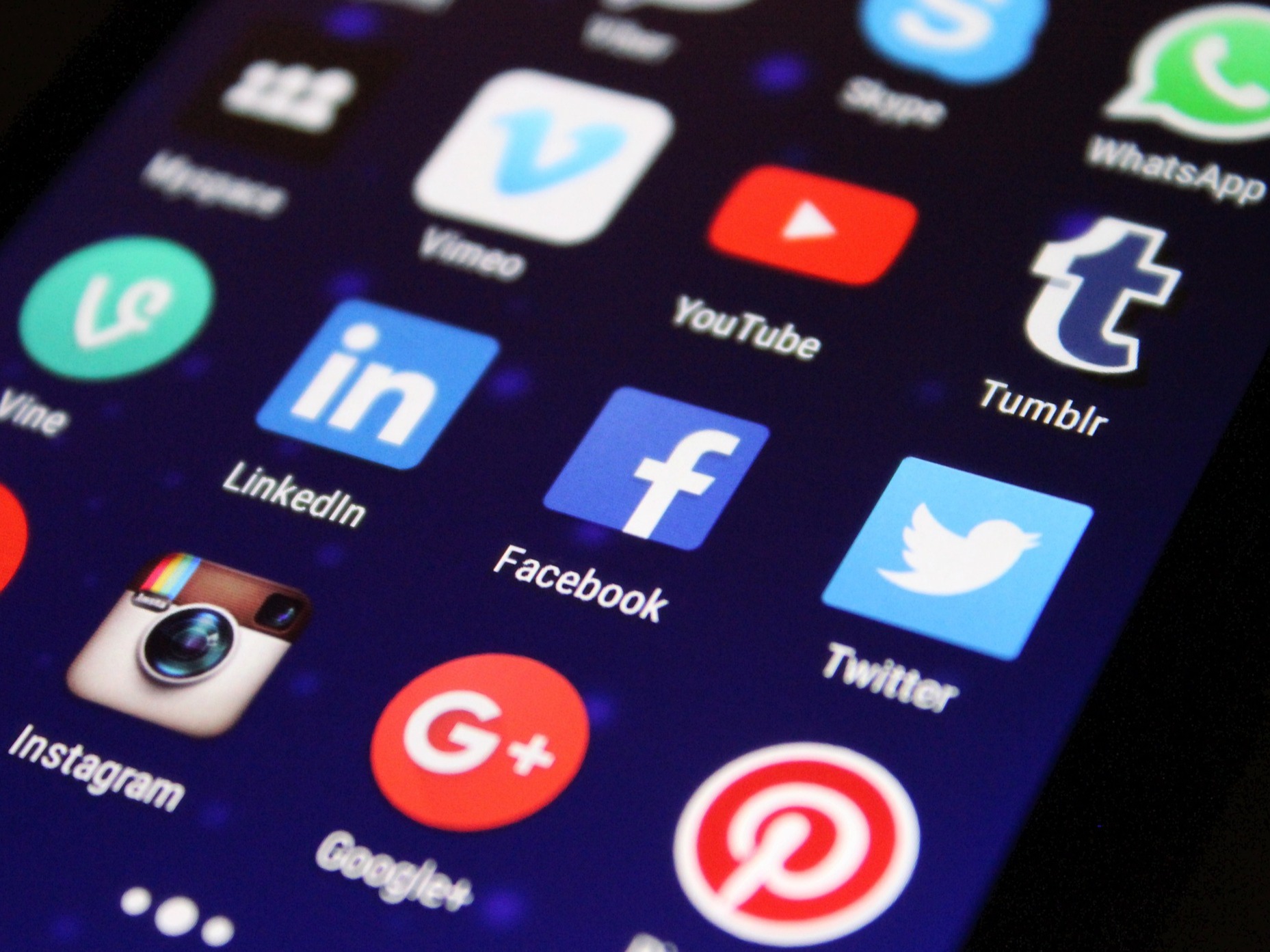An image of a phone with various social media app icons.
